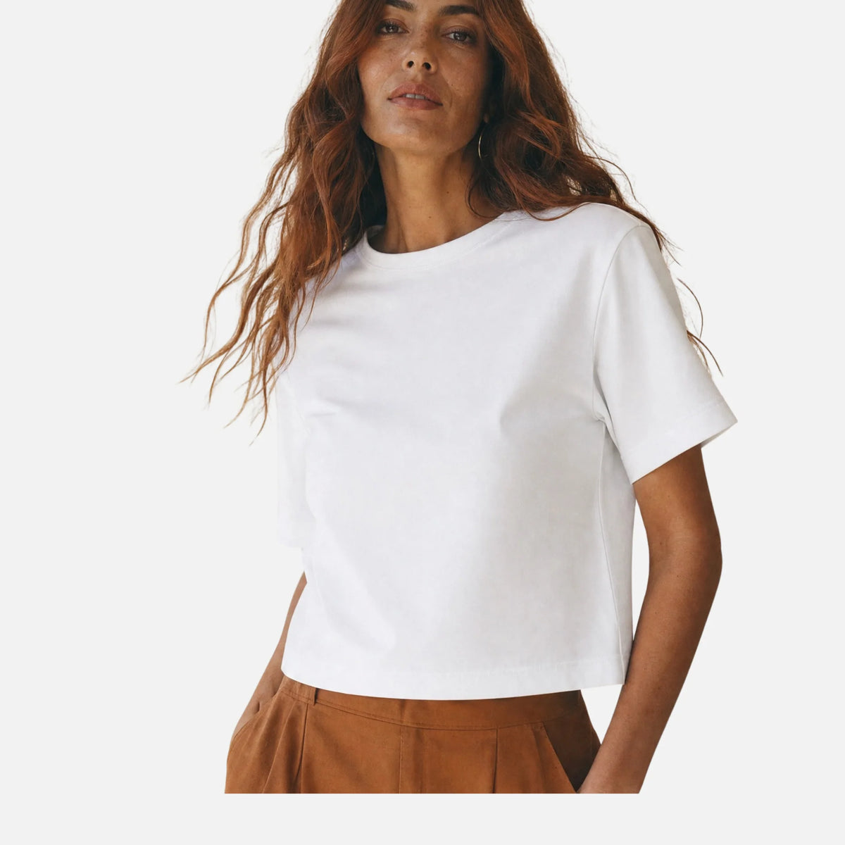 Mujer con camiseta blanca gruesa, la prenda que más se repite en el fondo de armario